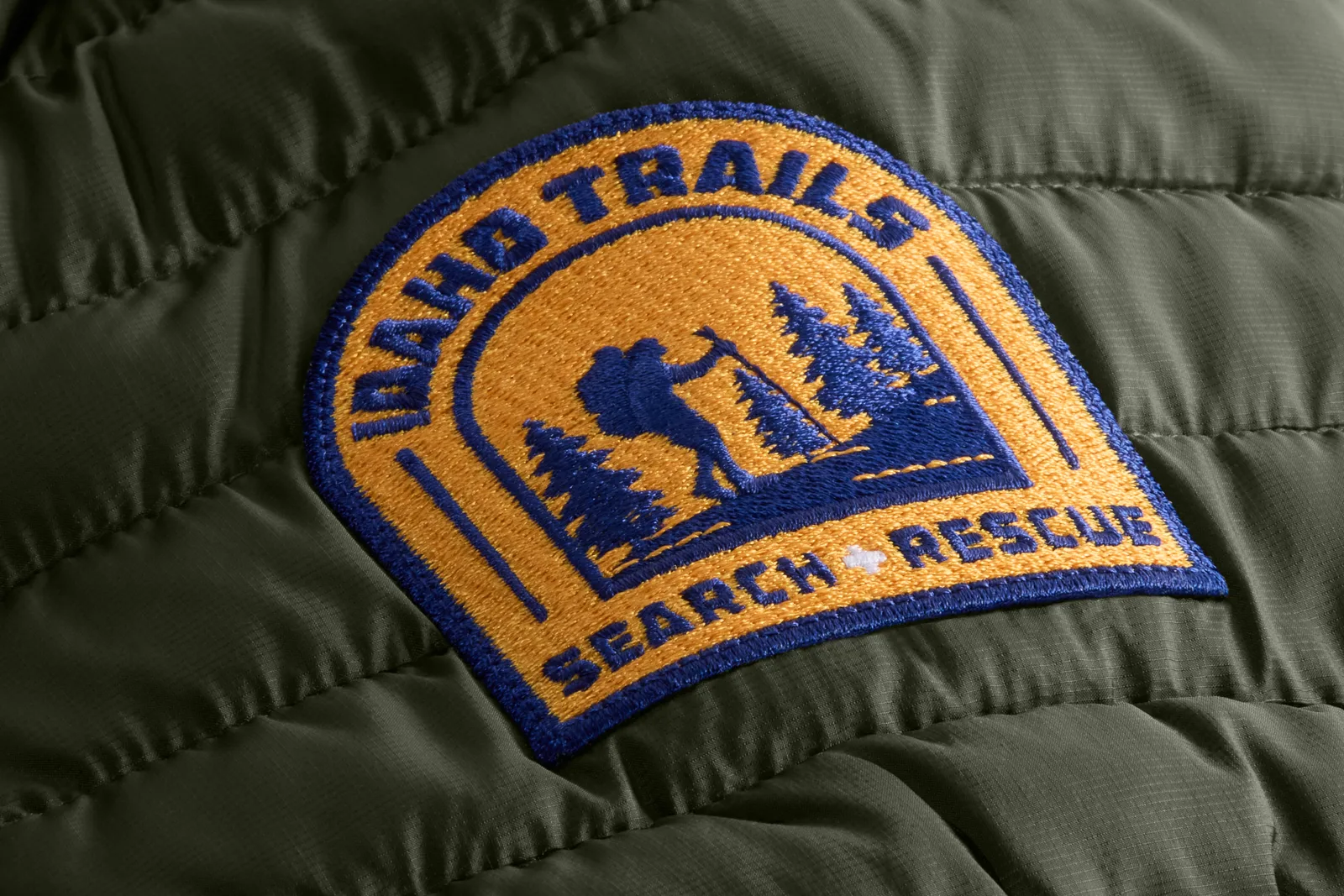 Embroidered patch on an olive puffer jacket